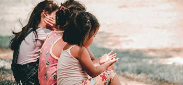 Group of children sitting on bench.